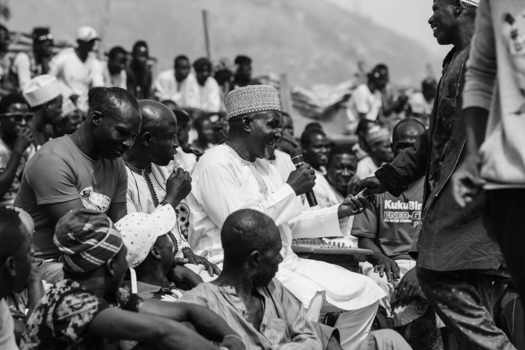 Candid black and white photo of a community gathering in Abuja, Nigeria.