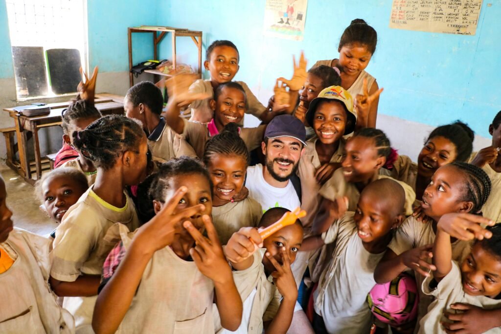 A group of smiling students in a lively classroom setting enjoying a moment of fun and happiness.